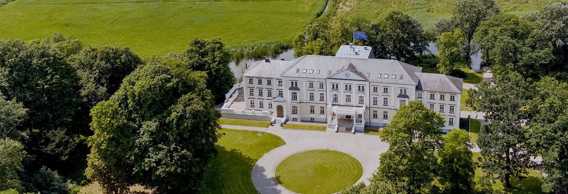 Luftaufnahme des Klinikums, eingebettet in ein saftiges, grünes Feld, das Frieden und Erholung ausstrahlt.