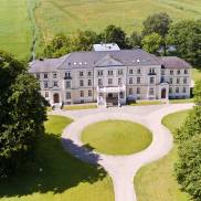 Blick von oben auf das Klinikum Schloss Lütgenhof, das von einer eleganten, runden Auffahrt umgeben ist.