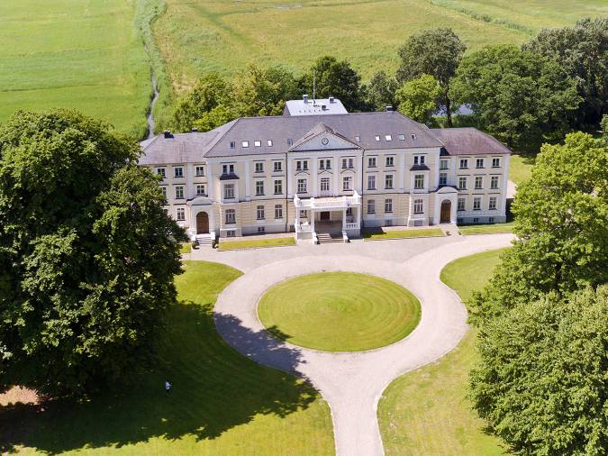 Blick von oben auf das Klinikum Schloss Lütgenhof, das von einer eleganten, runden Auffahrt umgeben ist.