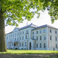Großes, weißes Gebäude der Psychosomatischen Klinik, das in einer friedlichen Umgebung steht.